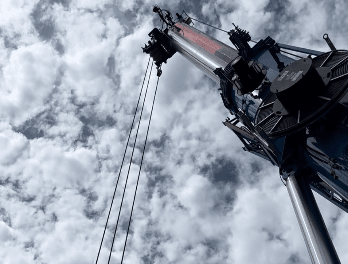 Nahaufnahme eines großen Kranarms gegen einen bewölkten Himmel gerichtet