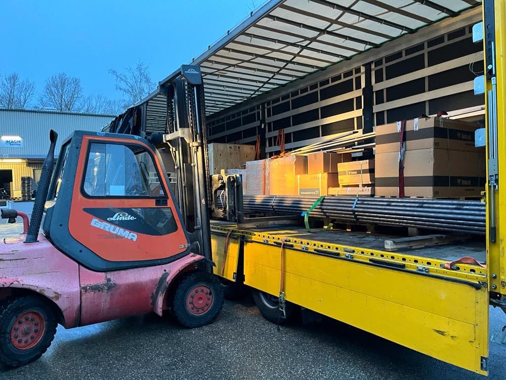 Ein Gabelstapler entlädt Aluminiumrohre aus einem türkischen LKW