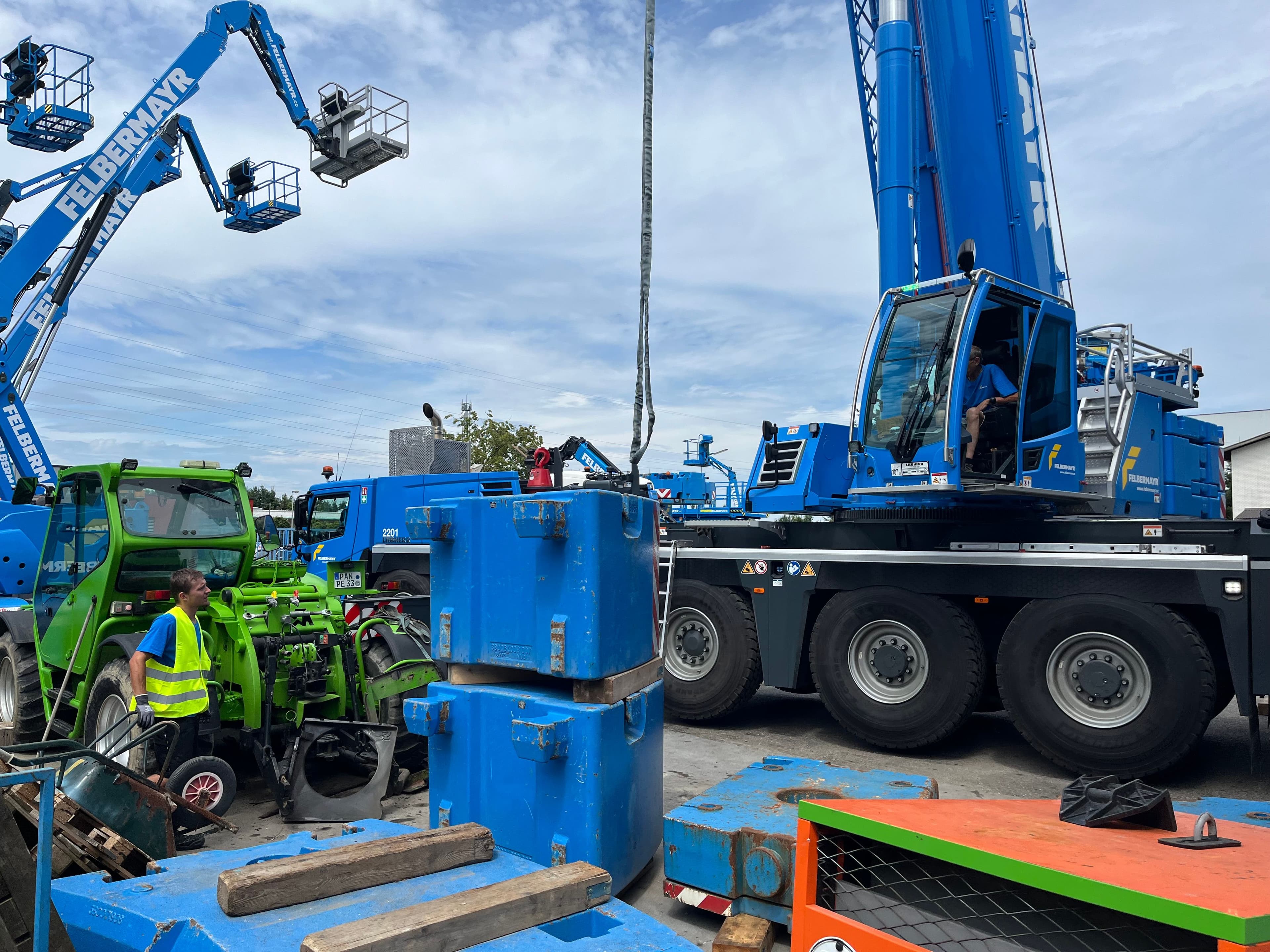 Blauer Kran, welcher mit Kettengehänge schwenkt