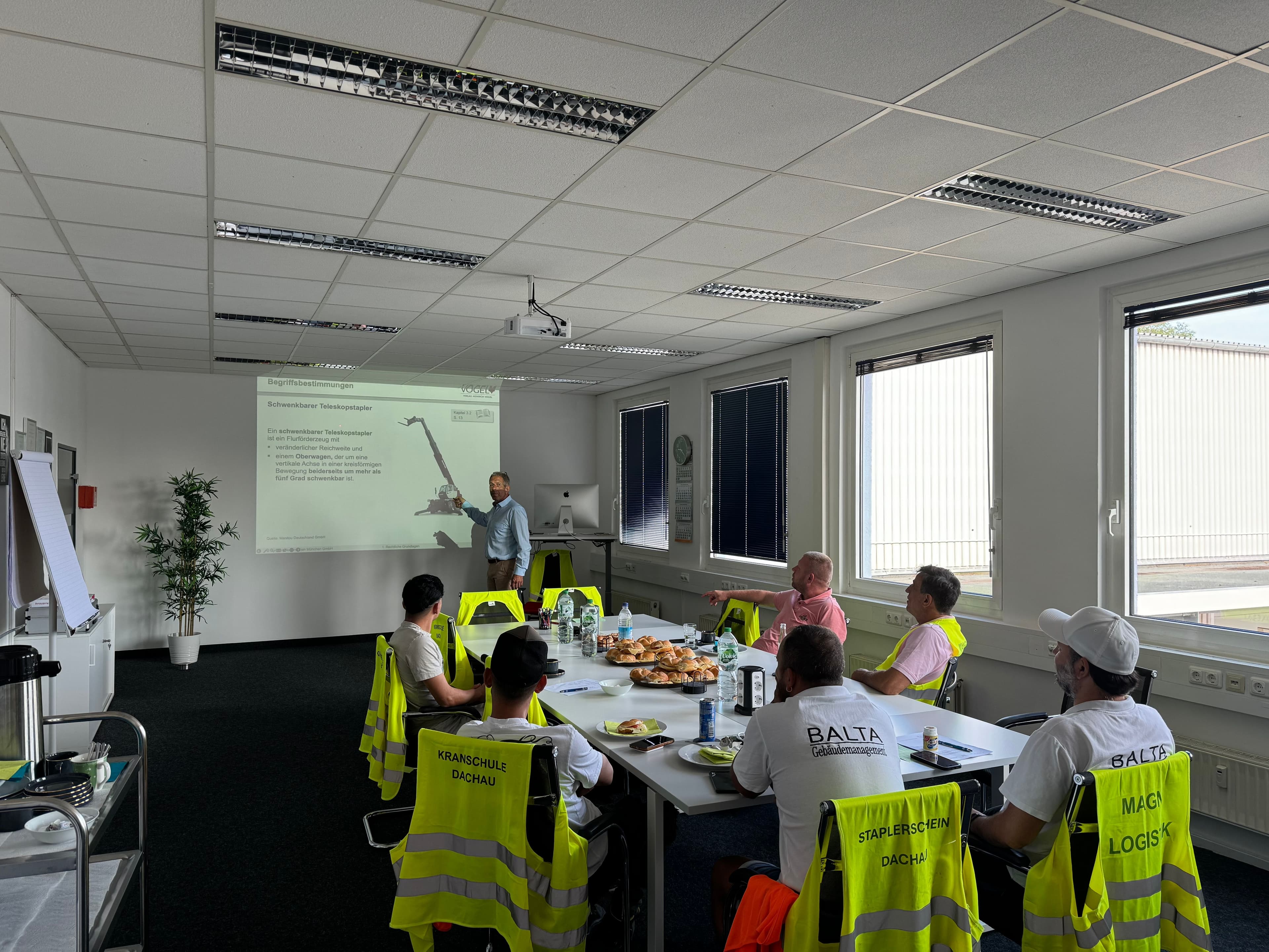 Gruppe von Schülern, die an einer Unterweisung teilnimmt mit einem Dozenten und Beamer