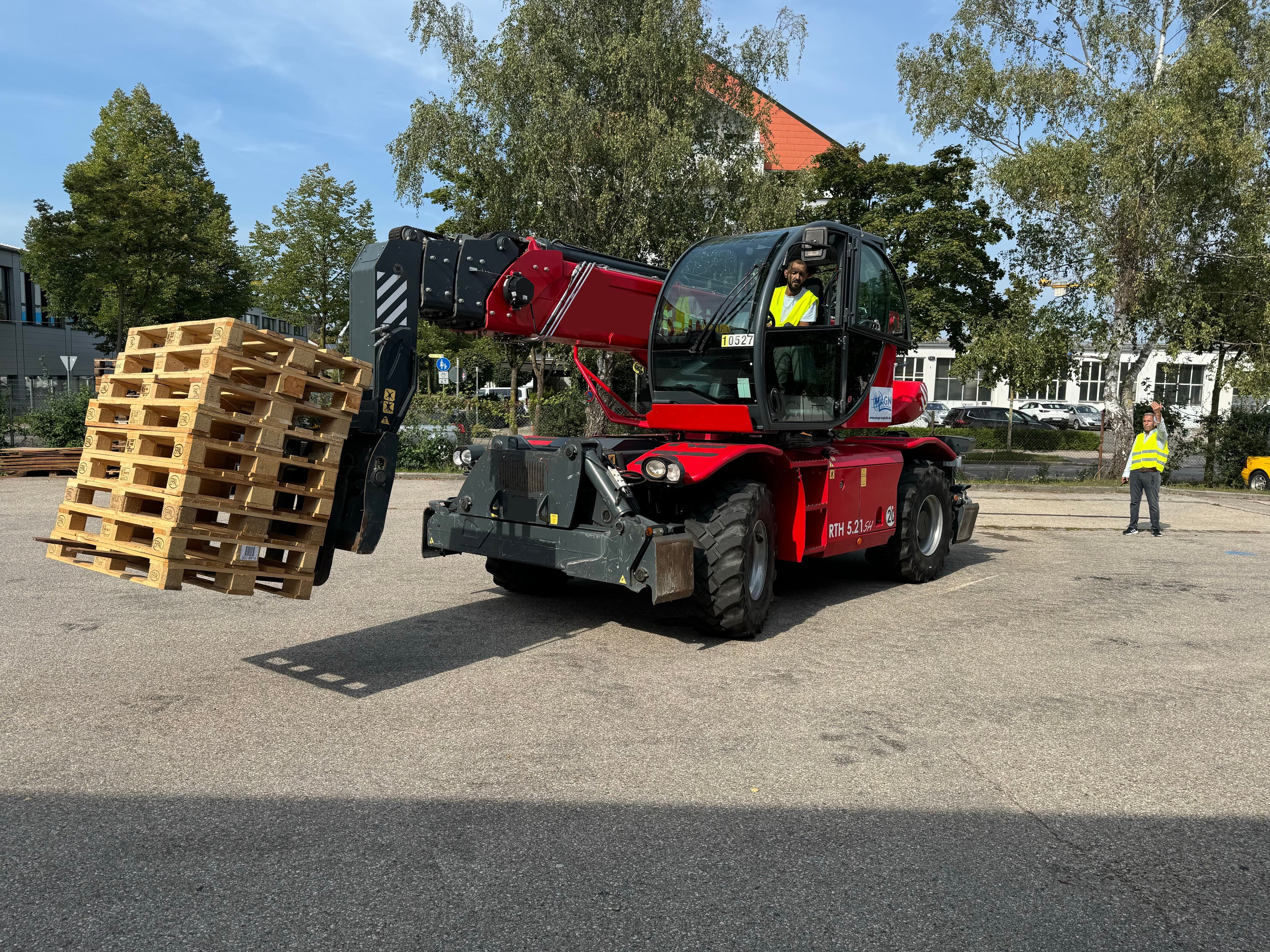 Teleskopstapler hebt mehrere Paletten während einer Schulung im Freien.