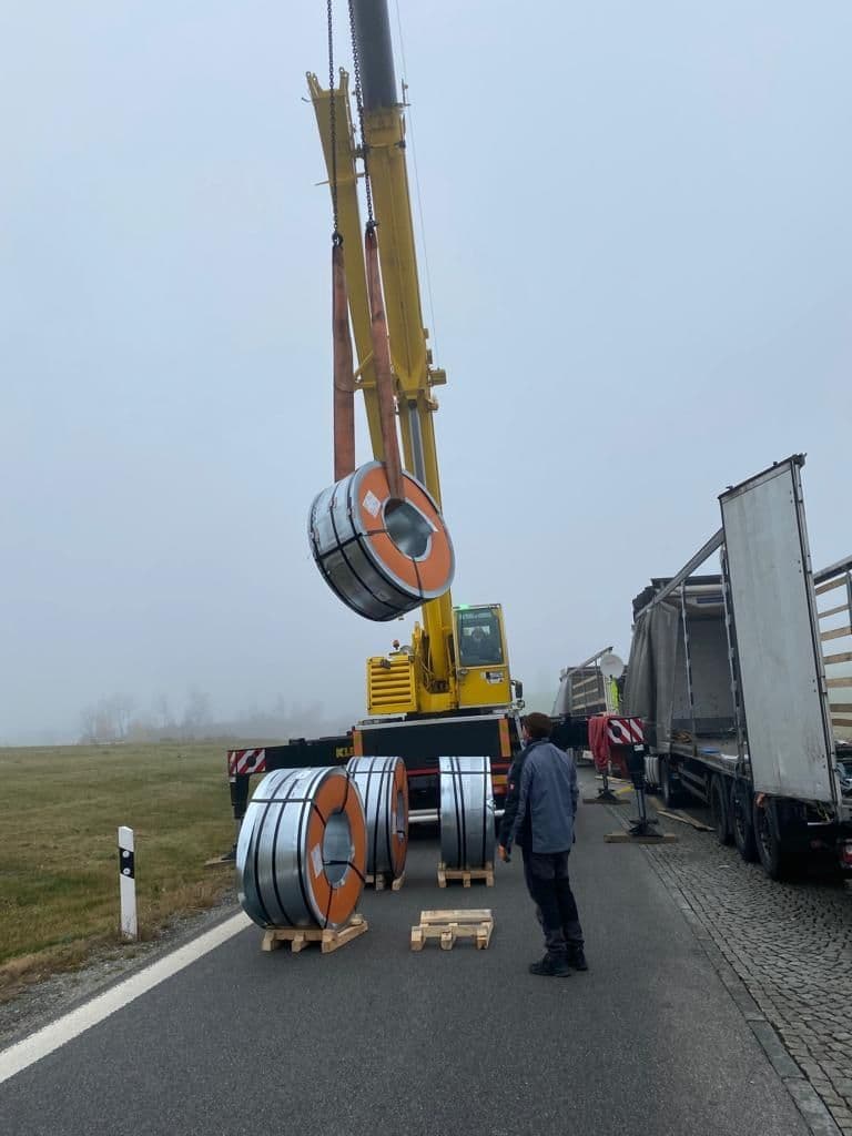 Autokran hebt 5to schwere Rolle Rolle mit einem Schlupf hoch